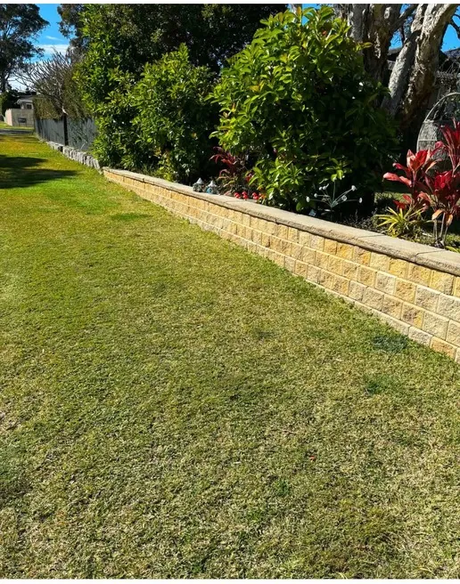 Maintained garden bed along a sandstone wall